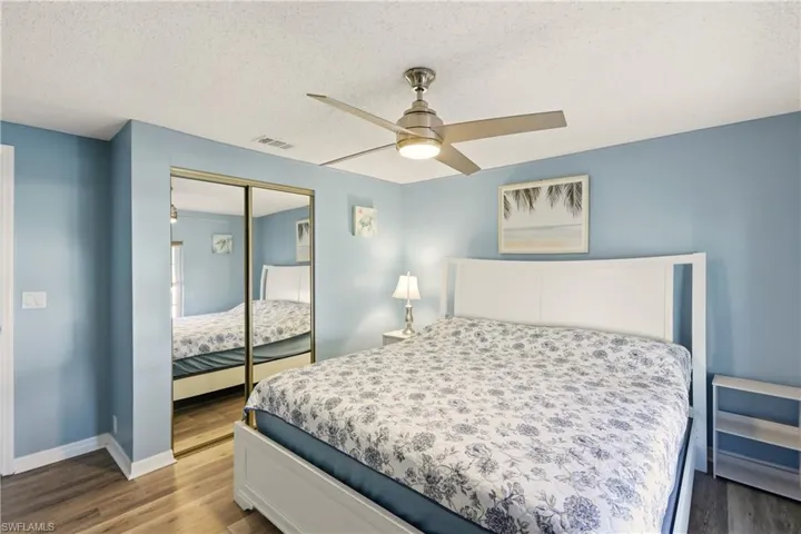 Bedroom featuring dark wood finished floors, a textured ceiling, a closet, and a ceiling fan