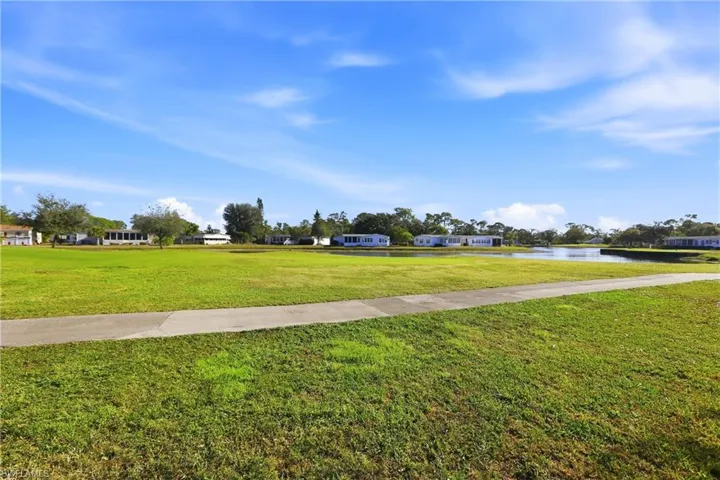 Surrounding community with a lawn and a water view