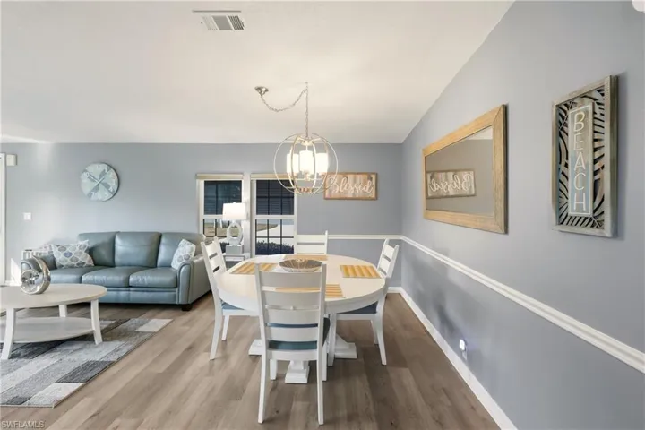 Dining space with wood finished floors and a chandelier