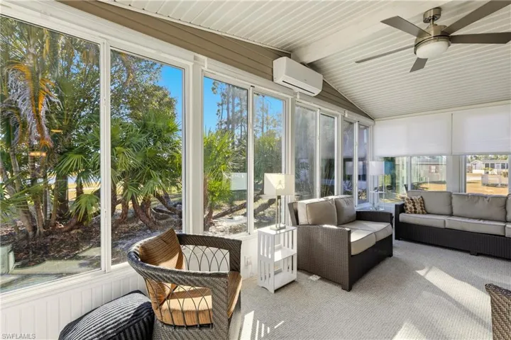 Sunroom / solarium with a ceiling fan, outdoor lounge area, a wall mounted AC, and vaulted ceiling