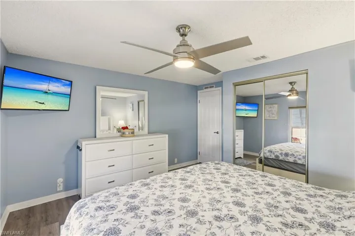 Bedroom featuring ceiling fan, a closet, dark wood-style floors, and a textured ceiling