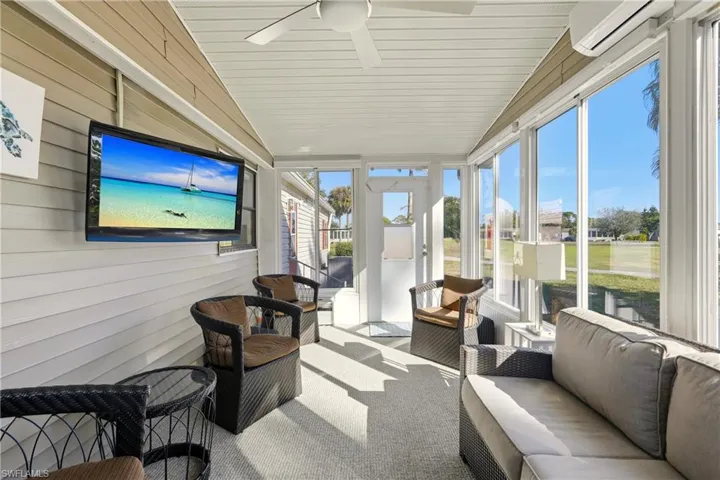 Sunroom with an outdoor hangout area, ceiling fan, lofted ceiling, and a wall mounted AC