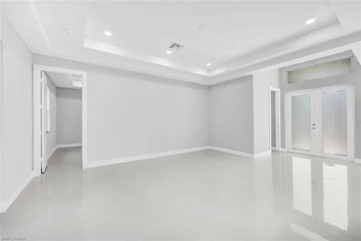 Empty room with a raised ceiling and concrete floors