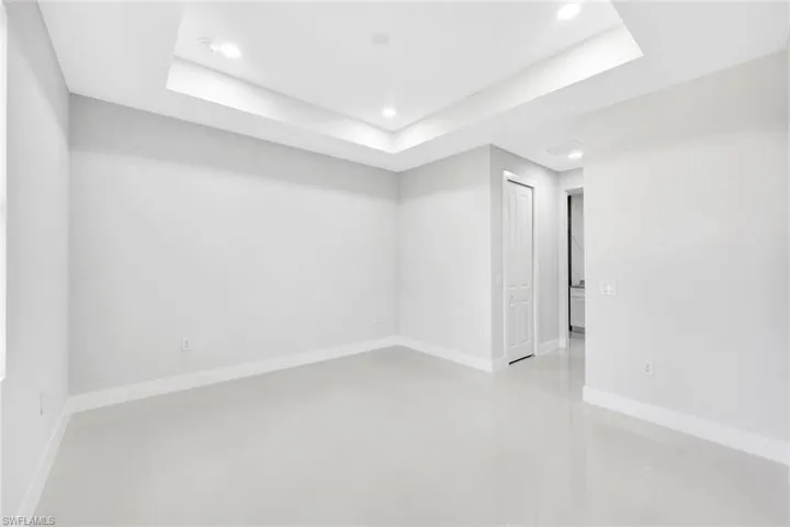 Empty room featuring tile floors and a raised ceiling