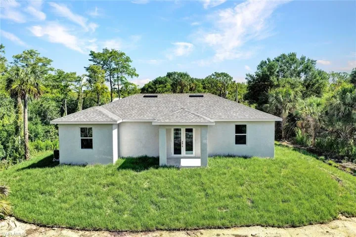Rear view of house featuring a lawn