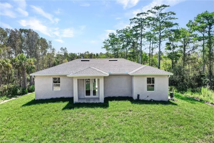 Rear view of property with a lawn