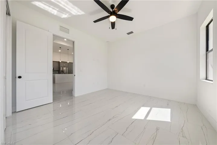 Unfurnished room featuring visible vents, baseboards, and a ceiling fan