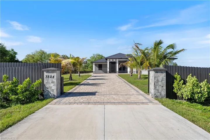 View of front facade with a front yard, decorative driveway, and a fenced front yard