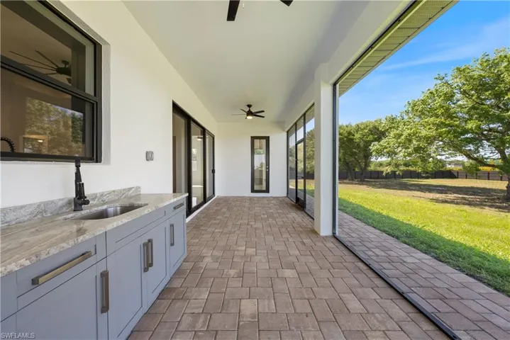 Unfurnished sunroom with a sink and ceiling fan