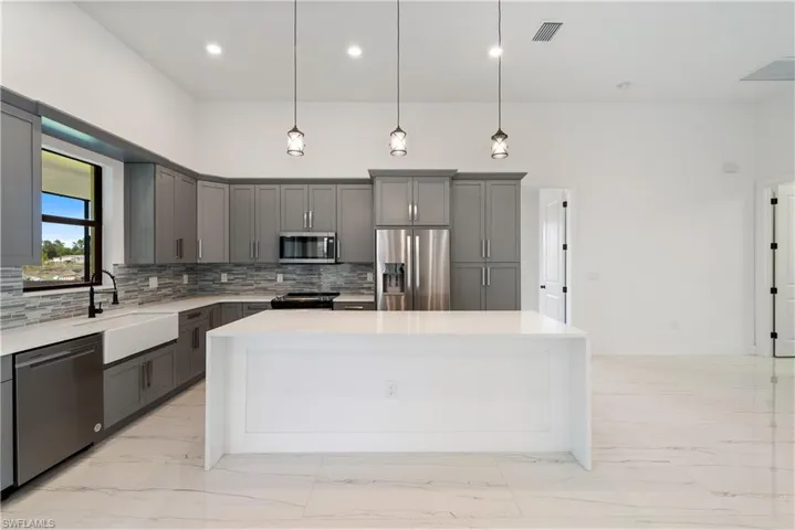 Kitchen with visible vents, gray cabinets, stainless steel appliances, marble finish floor, and a center island