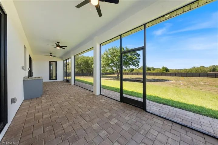 Unfurnished sunroom featuring a ceiling fan and a sink