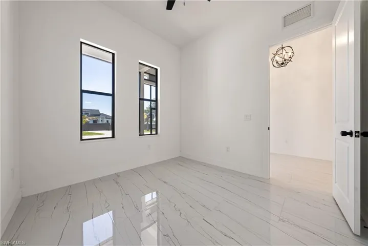 Unfurnished room featuring visible vents, marble finish floor, baseboards, and ceiling fan