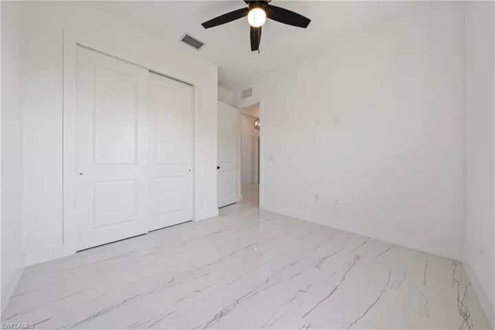 Unfurnished bedroom featuring a closet, visible vents, ceiling fan, and baseboards