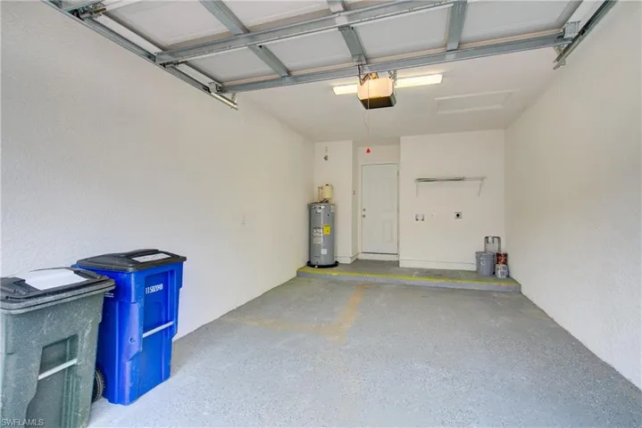 Garage featuring a garage door opener and water heater