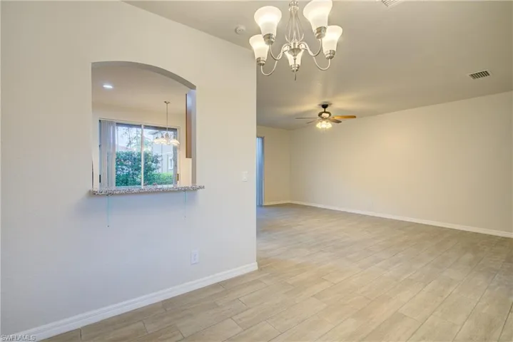 Empty room with ceiling fan with notable chandelier