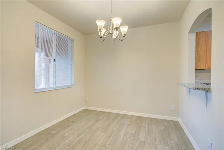 Unfurnished dining area featuring a notable chandelier and light wood-type flooring