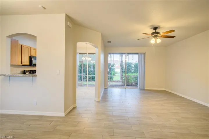 Unfurnished room featuring ceiling fan with notable chandelier