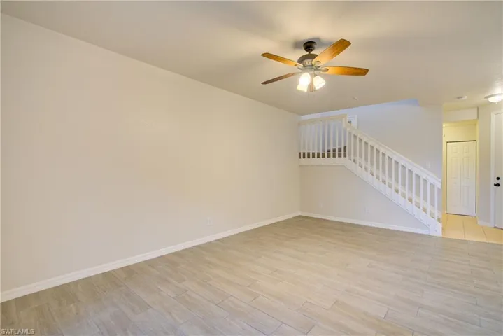 Empty room with ceiling fan and light wood-type flooring