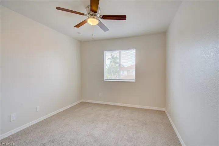 Carpeted empty room with ceiling fan