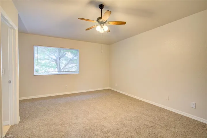 Carpeted bedroom featuring ceiling fan