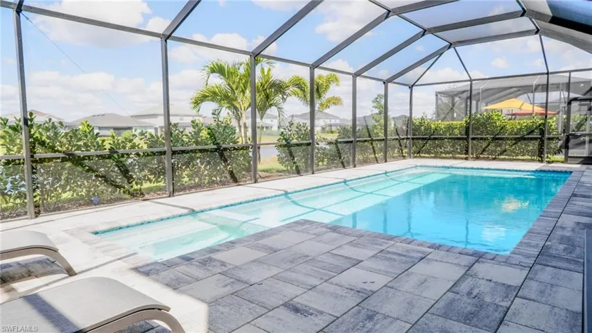 Integrated pool / hot tub featuring a sunroom, a lanai, and a patio