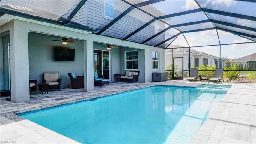 Integrated pool / hot tub featuring a sunroom, a patio area, glass enclosure, and an outdoor hangout area
