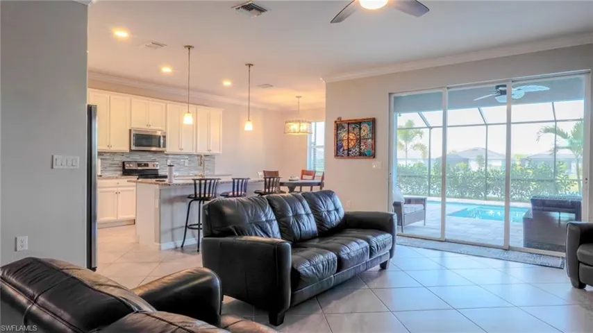 Living area featuring a ceiling fan, light tile patterned floors, ornamental molding, and recessed lighting