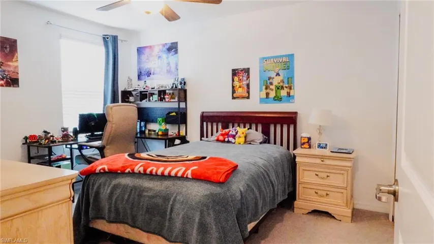 Carpeted bedroom with a ceiling fan