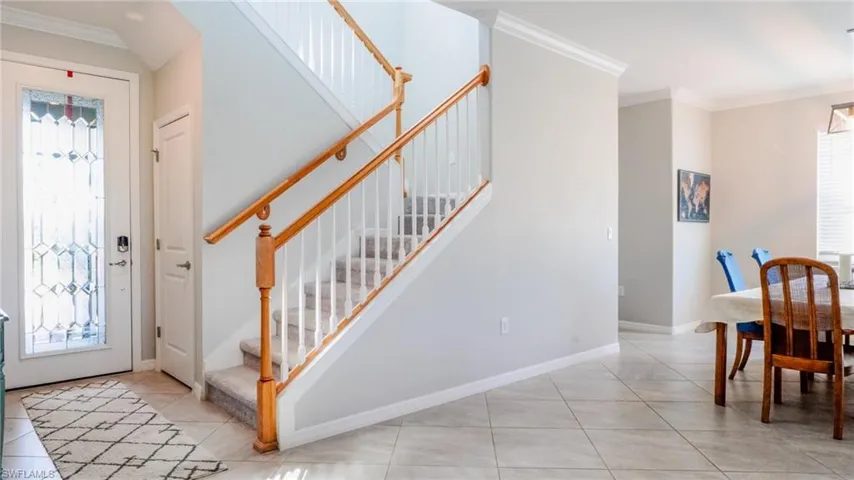 Foyer featuring crown molding and light tile patterned floors