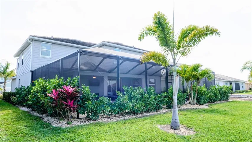 Back of house featuring a sunroom, glass enclosure, and a yard