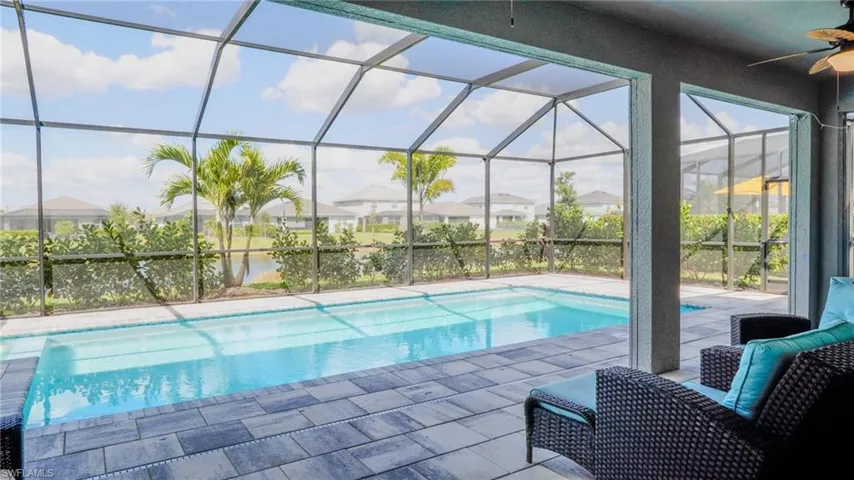 Swimming pool with a sunroom, a patio, and glass enclosure