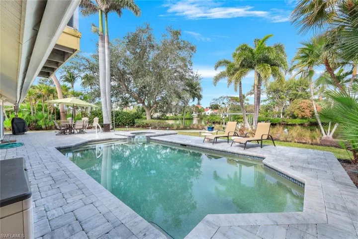 View of pool with a patio and an in ground hot tub