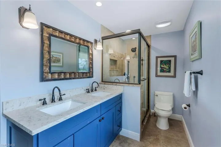 Primary Bathroom with toilet, vanity, and a shower with shower door