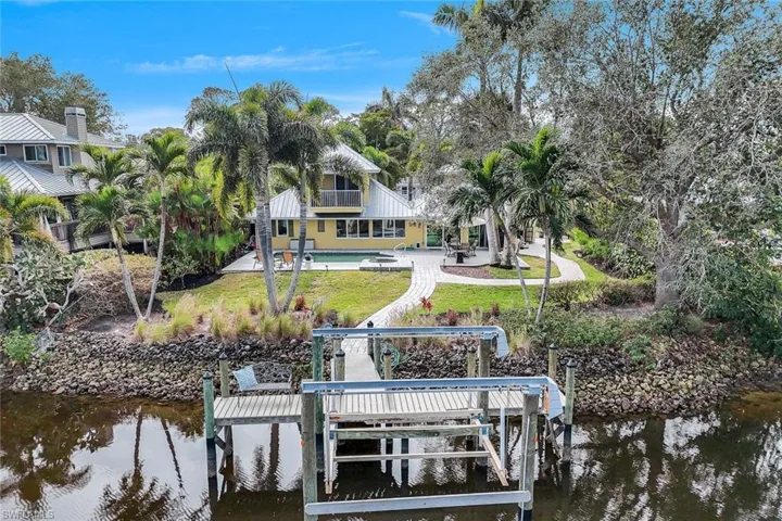 Dock area featuring a patio area, a lawn, and a water view