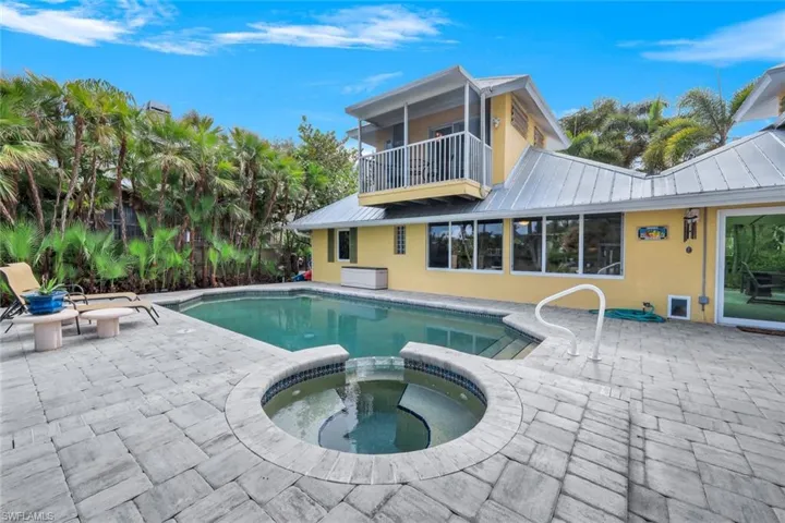View of pool with a patio and an in ground hot tub