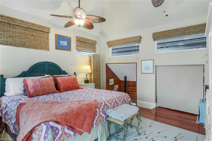 Upstairs Guest Bedroom with ceiling fan, wood-type flooring, and multiple windows