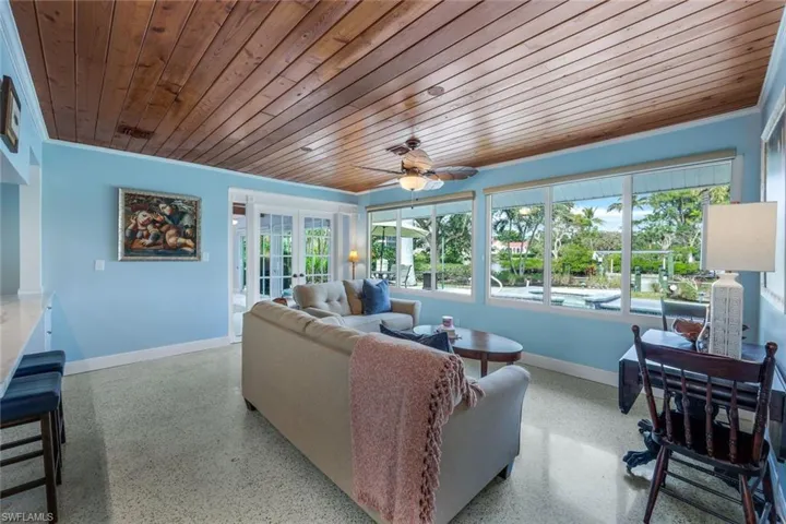 Living room featuring ornamental molding, wooden ceiling, french doors, and ceiling fan