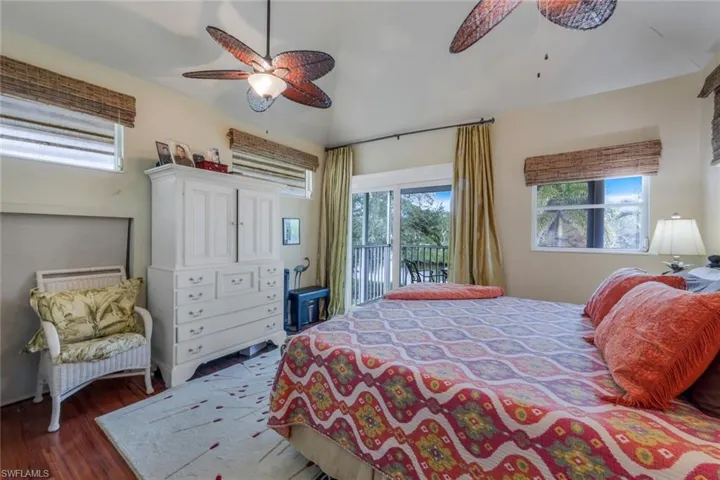 Upstairs Guest Bedroom featuring dark hardwood / wood-style flooring, access to balcony and ceiling fan
