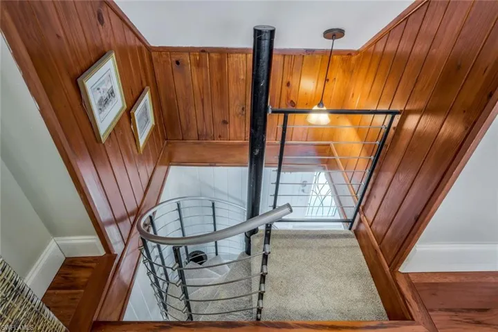 Staircase with carpet and wood walls to guest room