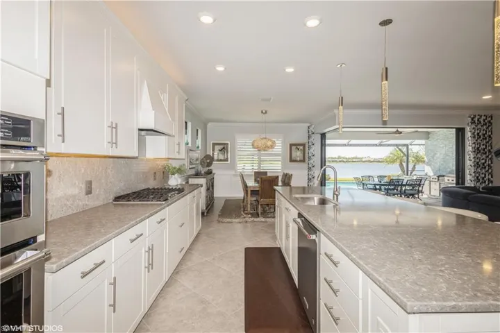 Kitchen with tasteful backsplash, sink, a wealth of natural light, and light tile patterned flooring