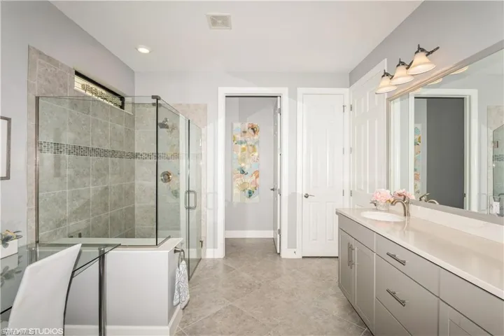 Bathroom featuring vanity, a shower with door, and tile patterned flooring