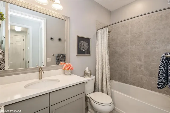 Full bathroom featuring shower / bath combo with shower curtain, vanity, and toilet