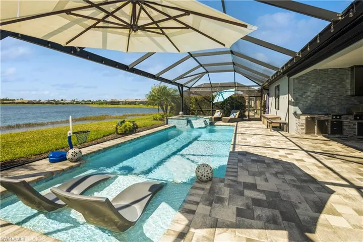 View of pool with a lanai, a patio, and a water view
