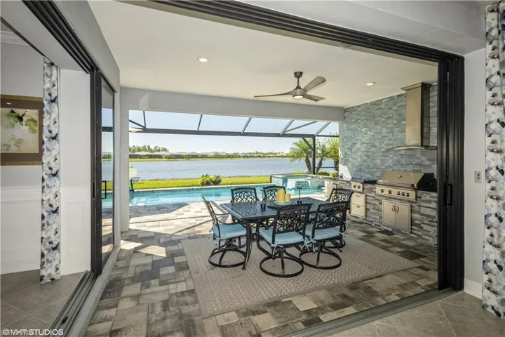 Sunroom / solarium with ceiling fan and a water view