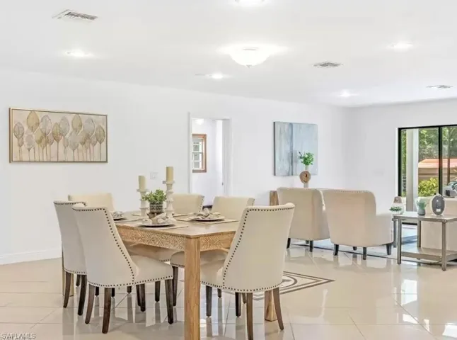 Dining space with light tile patterned flooring and recessed lighting