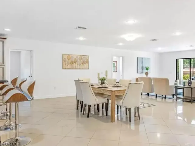 Dining space with light tile patterned floors and recessed lighting