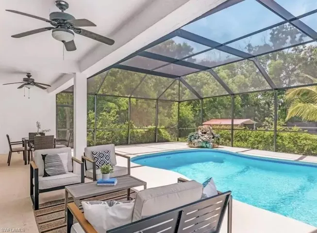 Outdoor pool with outdoor dining area, a sunroom, outdoor lounge area, glass enclosure, and a patio area