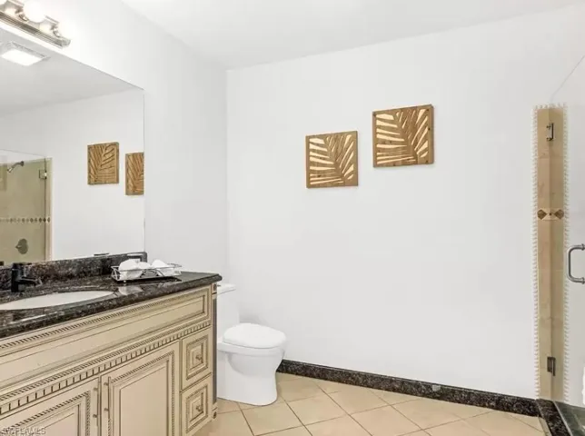 Full bath with a shower stall, light tile patterned flooring, and vanity