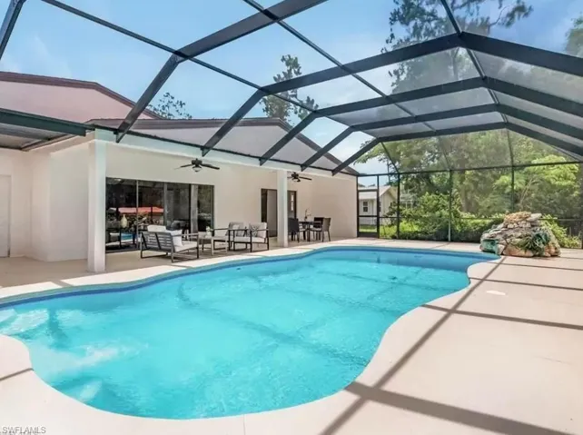 Swimming pool with a patio, a lanai, and a sunroom
