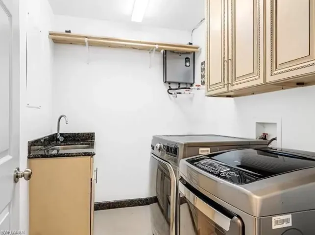 Laundry area with cabinet space, water heater, and washing machine and dryer